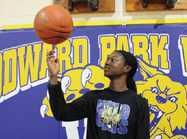 student balancing basketball on finger